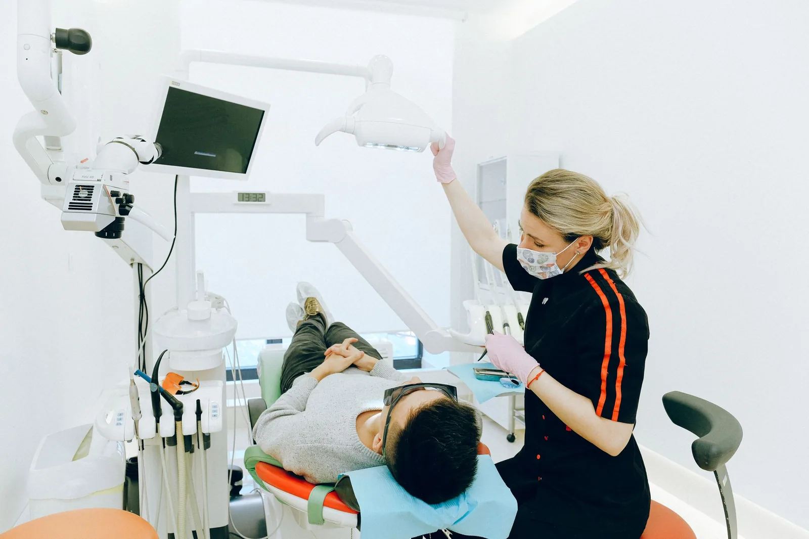 Cirurgião-dentista realizando exame preventivo da boca de uma paciente