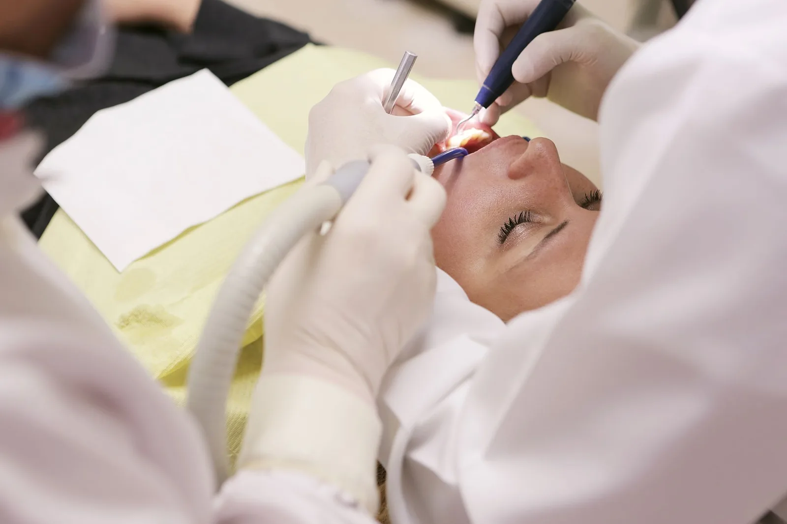 Dentista examinando a gengiva de uma paciente durante consulta odontológica