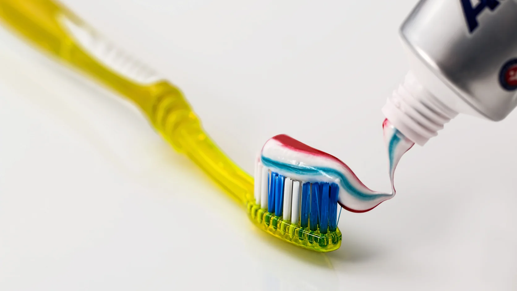 Escova infantil com quantidade adequada de creme dental fluoretado para escovação supervisionada